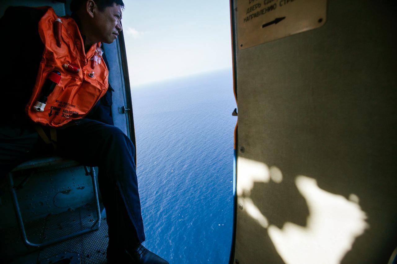 Un militaire scrutant l'horizon depuis un hélicoptère lors d'une mission de recherche au large de l'île Tho Chu, Vietnam, le 10 mars 2014.